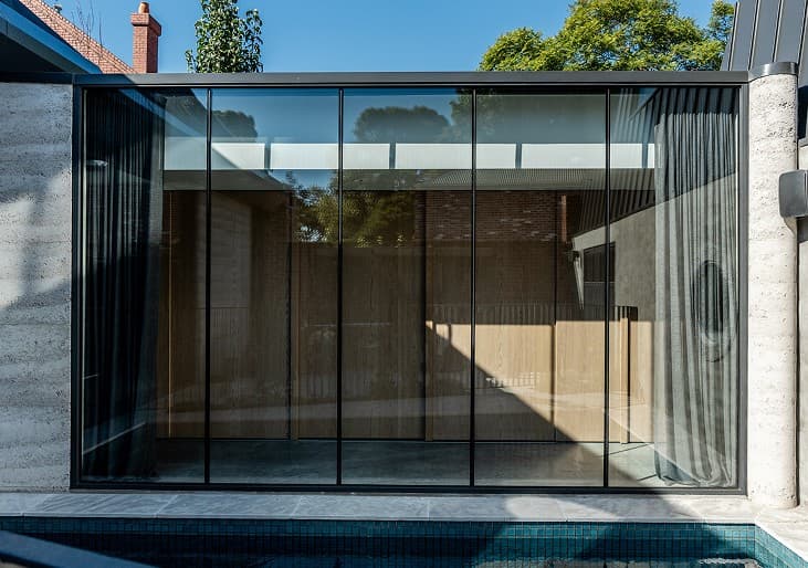 Glass pool pavilion with full-height aluminium glazing