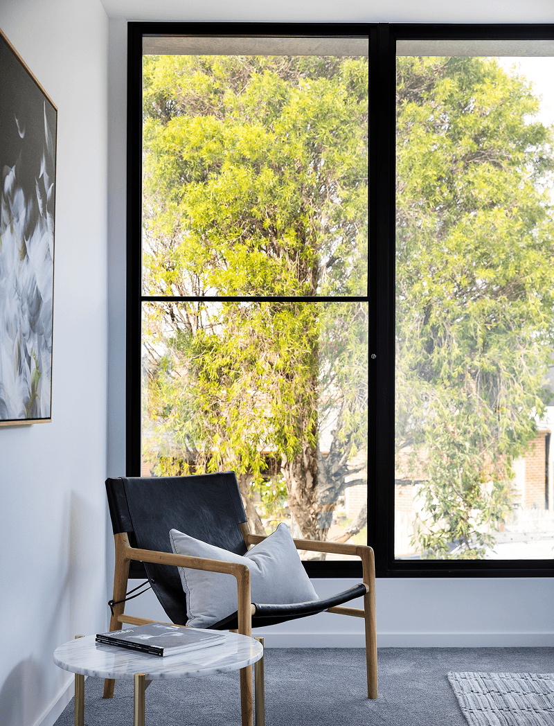 Vue project — black-framed window beside a leather chair